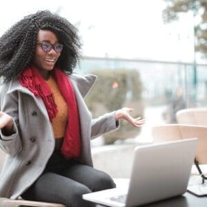 A woman sitting at a table with her laptop.