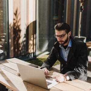 A man sitting at a table with a laptop.