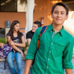 A young man in green shirt and blue jeans.